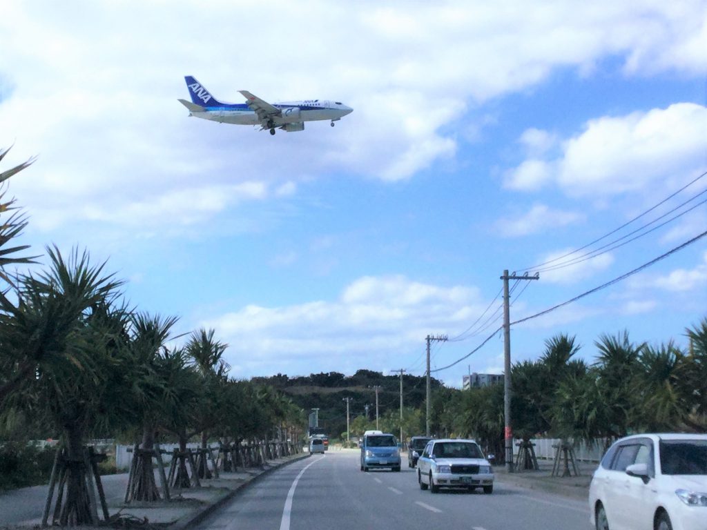 瀬長島海中道路上空を、飛行機が那覇空港に着陸体制
